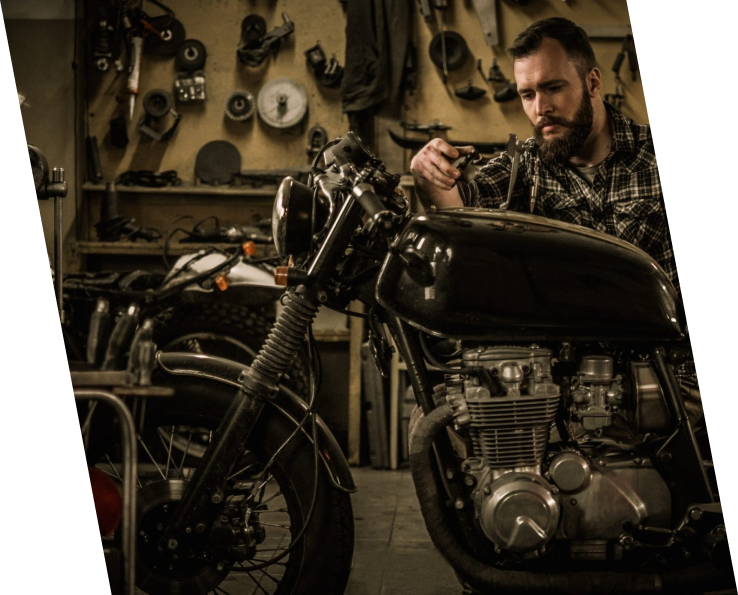 A man working on a motorcycle in a garage.